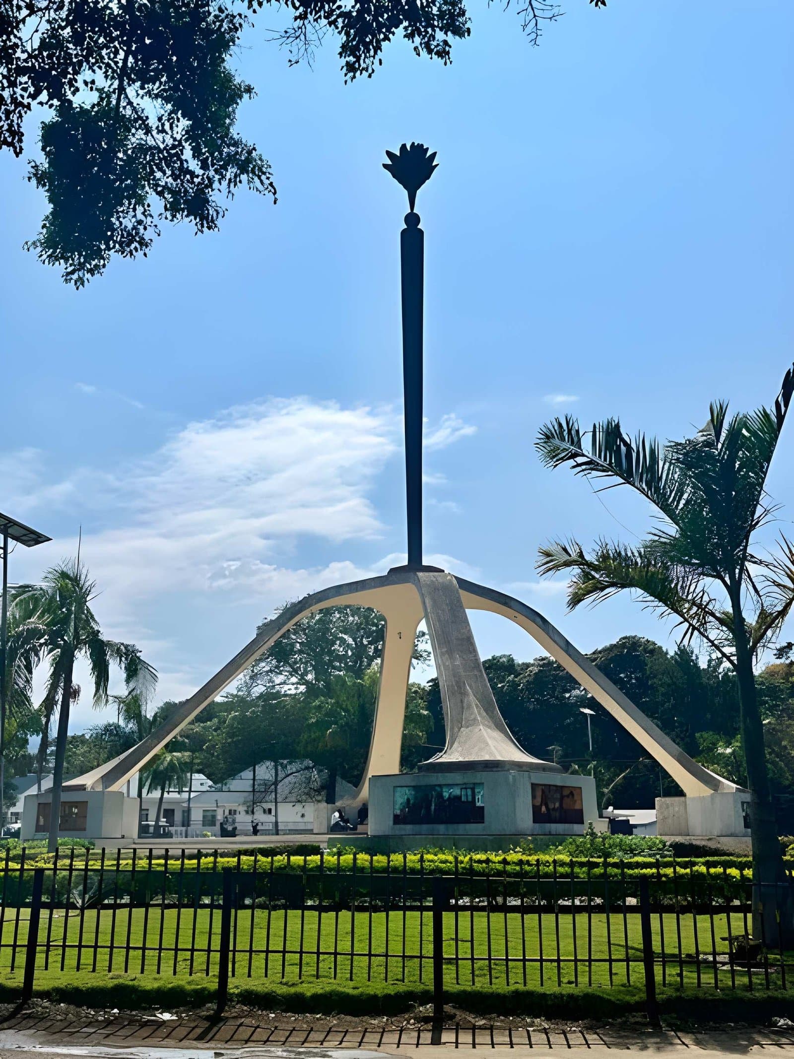 A monument framed by trees beneath a blue sky